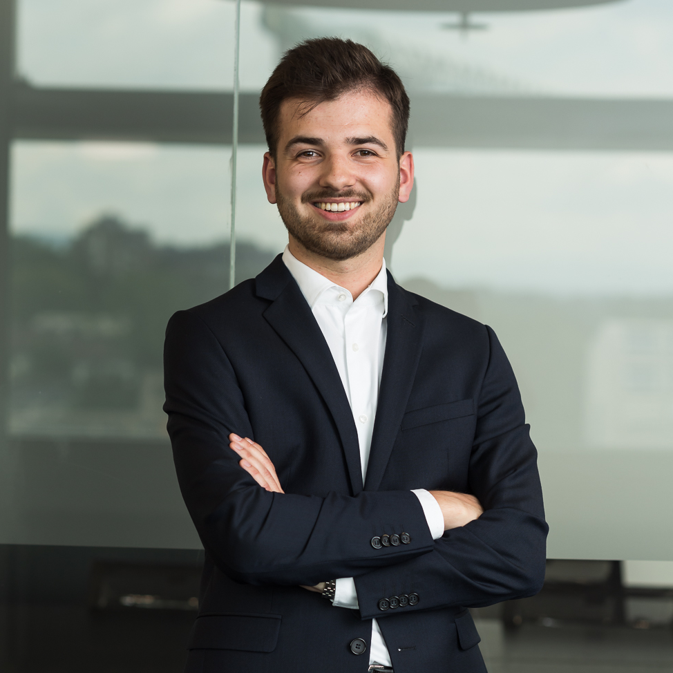 Andréa Autolitano – portrait of a Swiss lawyer at Suter Howald Attorneys at Law in Zurich, wearing a dark suit and smiling confidently in a modern office setting.